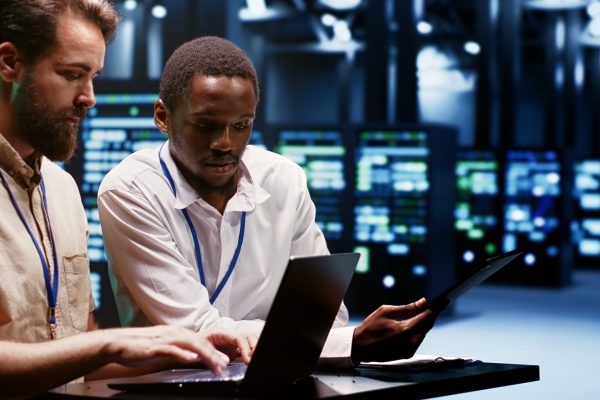 Teamworking experts doing maintenance on servers helping businesses manage databases, host websites and store files. Engineers monitoring supercomputers used for high performance computing